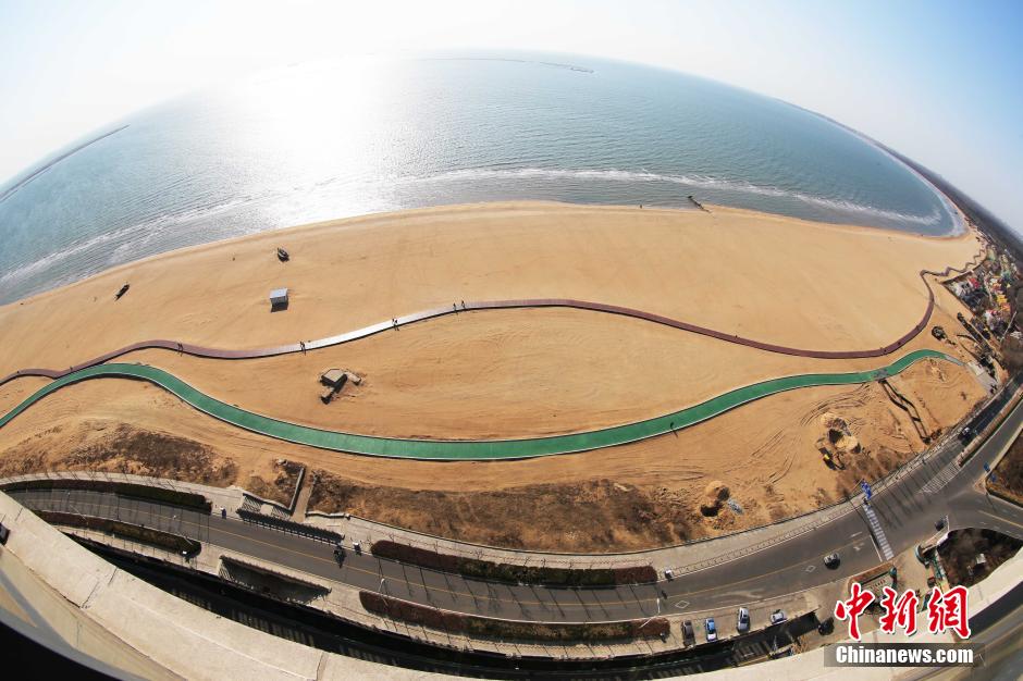 3月13日，秦皇島萬米臨海沙灘木棧道。據(jù)了解，該木棧道全長約4200米，與北戴河區(qū)原有的7500米木棧道對接后全線總長度1.17萬米，整個木棧道東起秦皇島體育基地游船碼頭，西至北戴河濕地公園，呈波浪形蜿蜒10.4公里海岸線。 中新社發(fā) 曹建雄 攝 CNSPHOTO